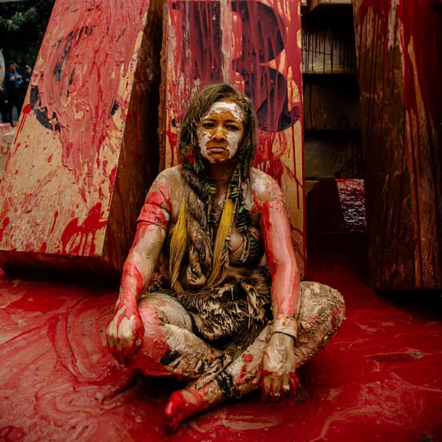 Angohó Pataxó senta-se coberta por uma mistura de lama e barro para protestar contra o assassinato de seu parente em Brasília há 25 anos por proteger o território de seu povo