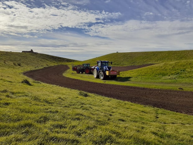 Tractors on a green space by the side of a road in Scotland.