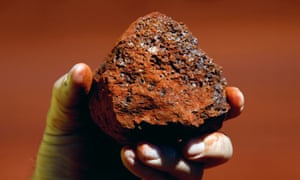 A miner holding a lump of iron ore.