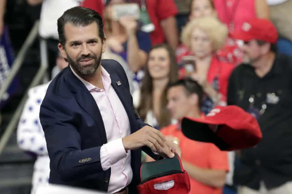 FILE - In this June 18, 2019, file photo, Donald Trump Jr. throws hats to supporters at a campaign rally for President Donald Trump in Orlando, Fla. (AP Photo/John Raoux)