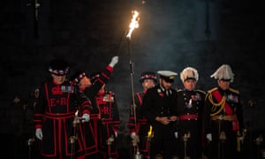Beefeaters light the first torches in the installation.