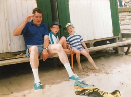 Taken on a family holiday in Swanage, Alistair (right), sits on a bench by the beach with his brother Tim and dad.