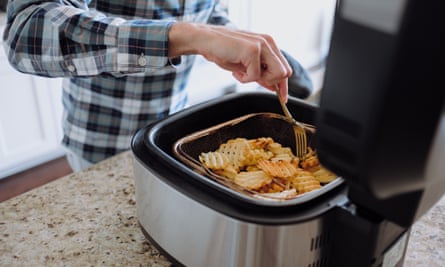 Man cooking waffle fries in an air fryer
