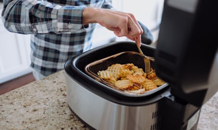 Man cooking potato waffles in an air fryer
