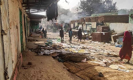 People walk among scattered objects in the market of al-Geneina, the capital of West Darfur.