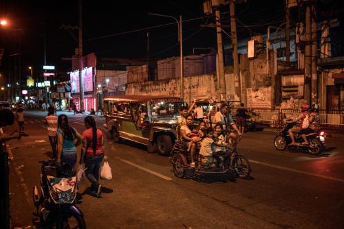 A pedi-trishaw filled to the brim with children on the main road outside of the Navotas slum, where Jasmine Durana lives.