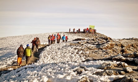 A group approaches the snowy summit of Kilimanjaro.