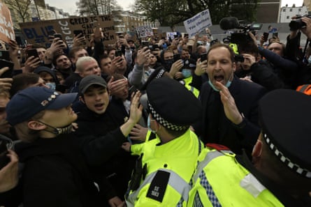 Former Chelsea goalkeeper Petr Cech, at right, behind a line of policemen, tries to calm down fans protesting outside Stamford Bridge