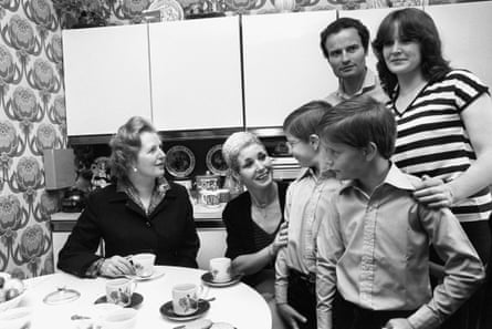 Margaret Thatcher with a family in a council house kitchen