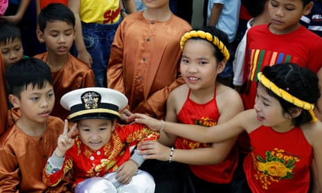 A child wears a US navy hat during a visit by sailors to Da Nang SOS Children’s Village