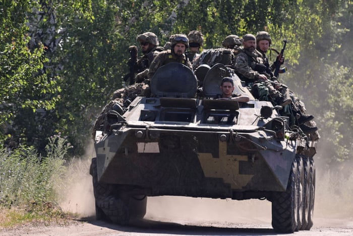Ukrainian soldiers sit on top of an armoured vehicle on a road in the countryside of Siversk, Donetsk.