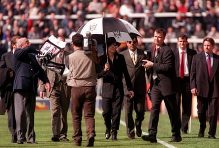 Pop Superstar Michael Jackson walks round the pitch at Craven Cottage as Mohamed Al Fayed (left) directs proceedings.