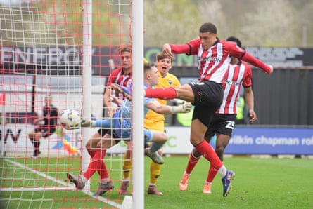 Ryan Oné scores from very close range, despite the best efforts of goalkeeper Nathan Bishop, to give Lincoln City a 1-0 win at home to AFC Wimbledon in their League One game.