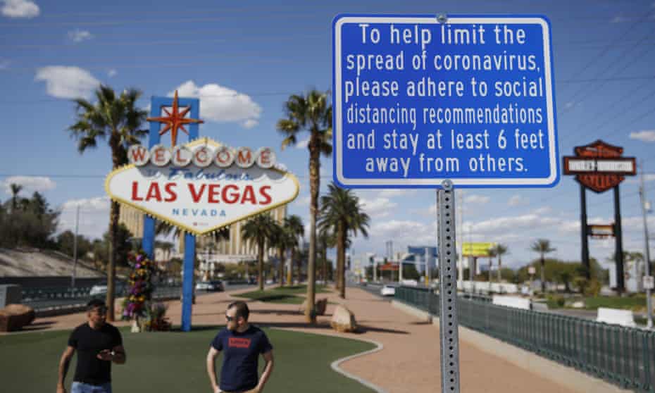 a sign advises people to practice social distancing to slow the spread of the coronavirus at the “Welcome to Fabulous Las Vegas Nevada” sign