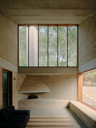 A tall brick room in Stuartholme House has high windows above a pyramid-shaped stepped fireplace