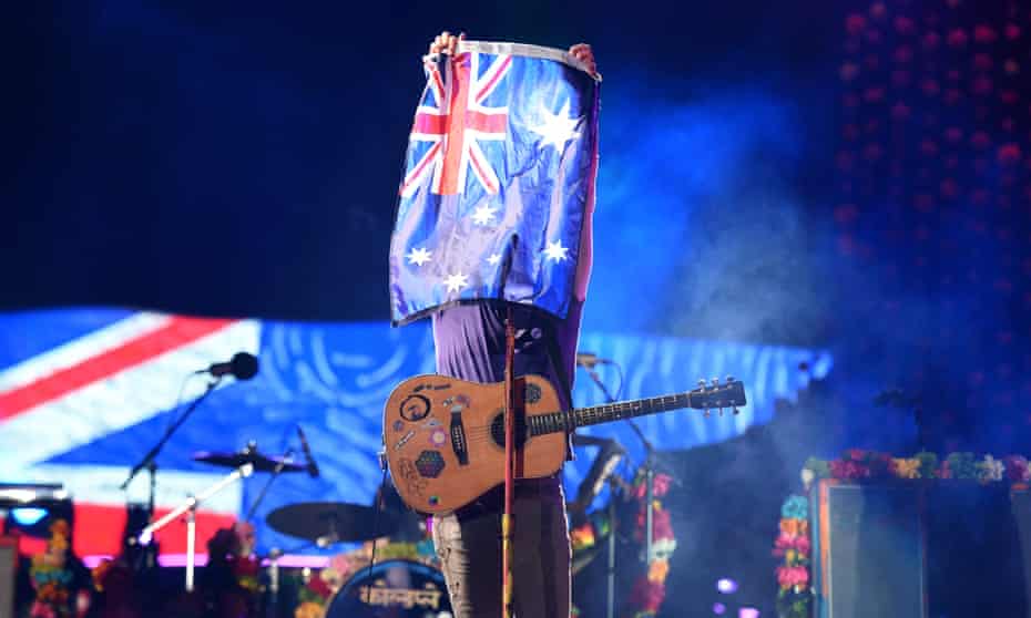 Chris Martin, lead singer of British rock band Coldplay, holds up the Australian flag as he performs at Suncorp Stadium in Brisbane in 2016.