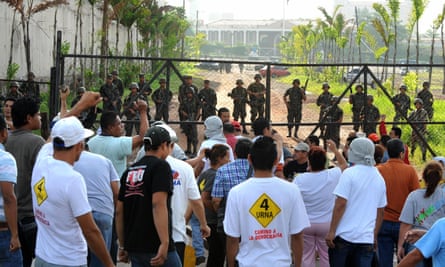 Angry Honduran civilians face troops near the presidential house in Tegucigalpa on 28 June 2009.