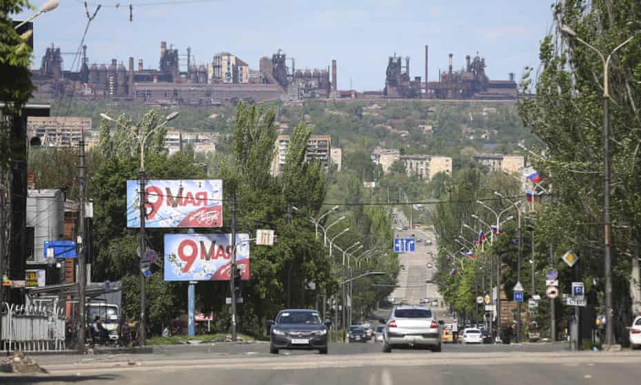 A street in Mariupol, with the Azovstal steel plant in the background
