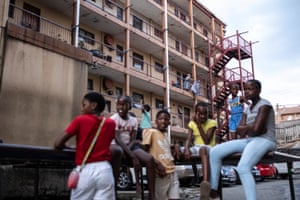 A resident hangs her laundry as children play on trampolines and others wait their turn in Alexandra near Johannesburg, South Africa