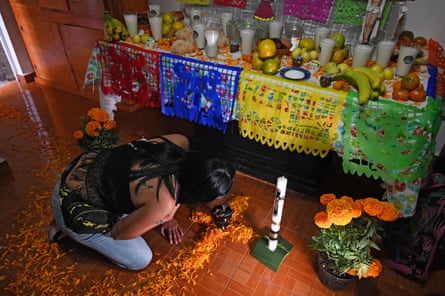 A relative of Alma Delia Romero Sánchez, who died from Covid-19, prepares an altar in her honour for the Day of the Dead in Mexico City.