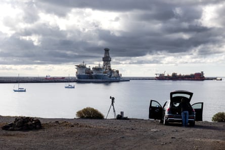 A member of the press sets up a camera overlooking the port, which is mostly empty of ships
