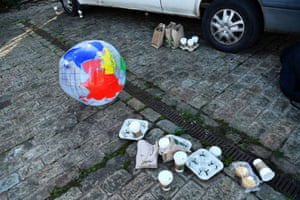 An inflatable globe rests beside rubbish left during a media event by climate activists