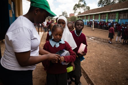 Students have their wristbands tapped so they can collect their food at Salama Primary school.