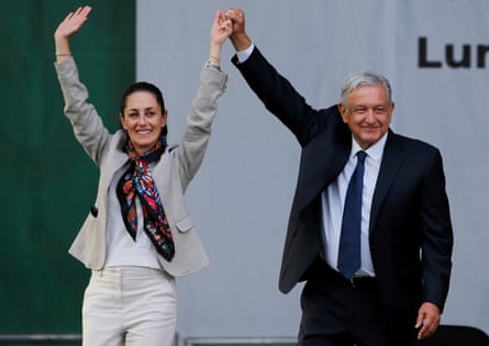 Man and woman hold raised hands between them, smiling.