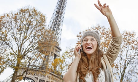 A young woman in Paris, in front of the Eiffel Tower. But is she using a smartphone or le mobile multifonction? 