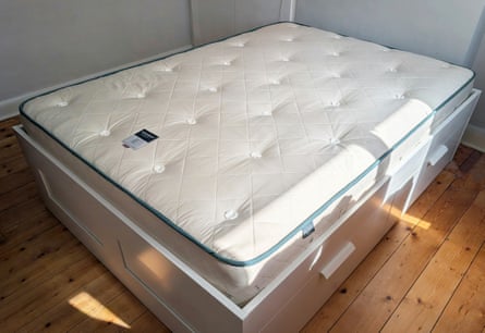 Bare mattress on wooden floor with sun coming in