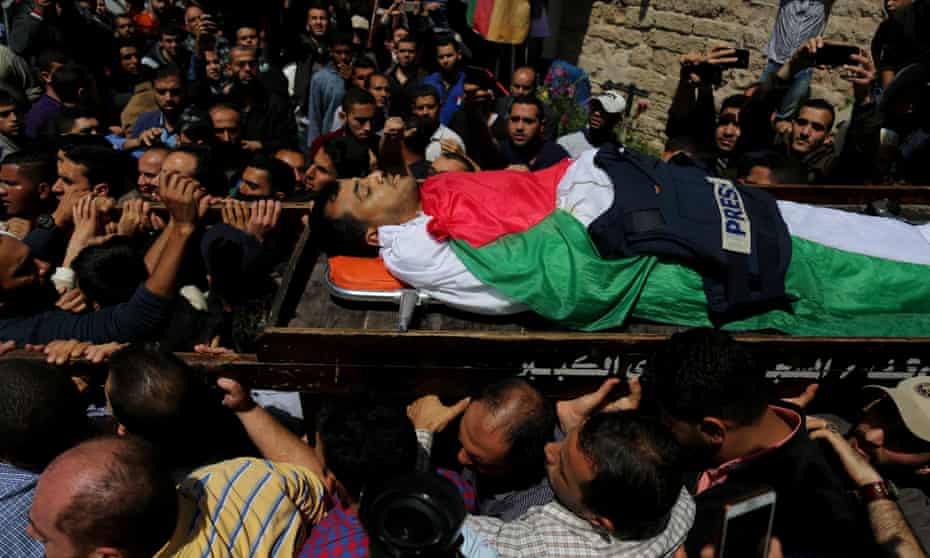 The Palestinian journalist Yasser Murtaja, shot while filming Israeli forces and a Palestinian protest, is carried to his burial on Saturday.