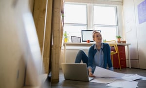 Architect reviewing blueprints on office floor