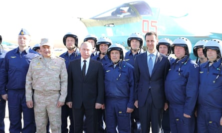 Vladimir Putin (third left) and Bashar al-Assad (third right) pose with pilots at Khmeimim airbase
