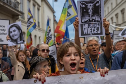 A young woman shouts while holding a protest banner at a Polish anti-abortion-law march