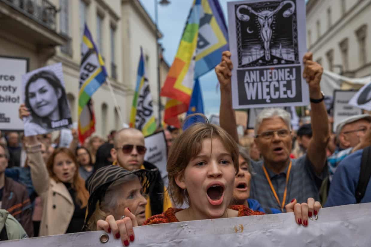 A young woman shouts while holding a protest banner at a Polish anti-abortion-law march