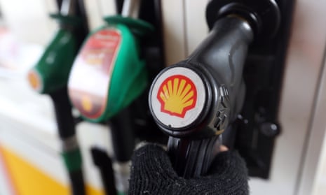 A Shell logo on a fuel pump handle on the forecourt of a petrol station