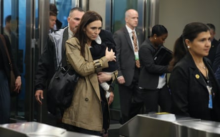 Ardern carries her baby up to a metal turnstile