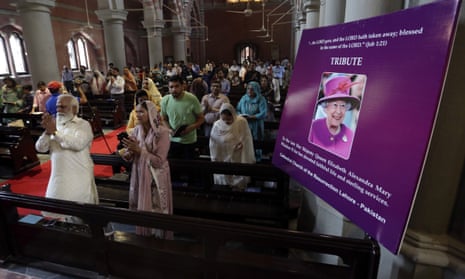 A portrait of the late Queen Elizabeth II is on display as people pay tribute to her during a Sunday prayer service at the Church of the Resurrection, in Lahore, Pakistan