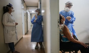 A health worker collects a swab sample from a woman to test for the coronavirus disease.