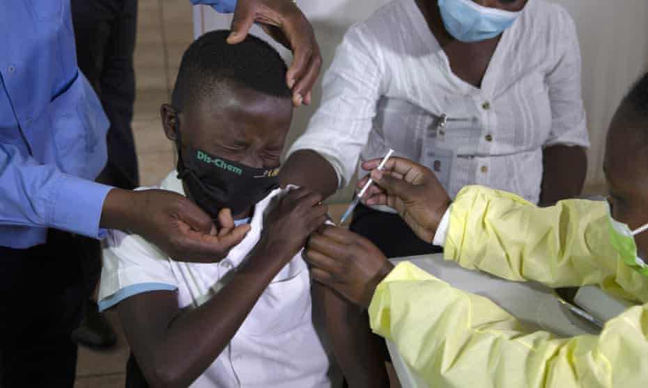 A child winces as he receives his Pfizer vaccine against Covid in a township near Johannesburg.