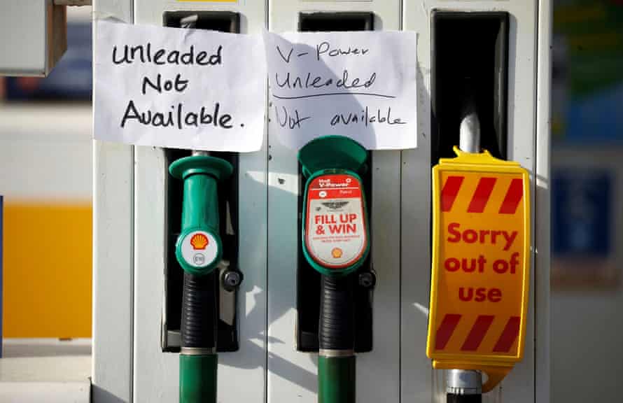 Des panneaux écrits à la main sont collés à une pompe à essence sans carburant disponible dans une station-service Shell à Manchester.