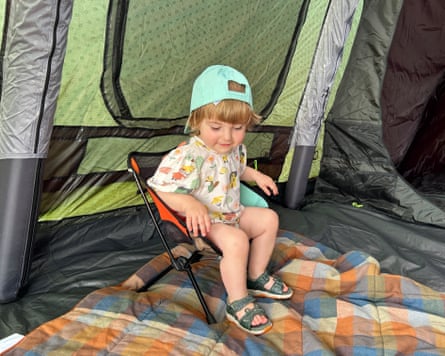 Sian Lewis’s daughter looks very happy to be sitting on a mini camping chair in a tent