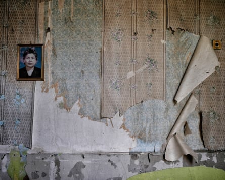 A portrait of a woman hanging on peeled wallpaper