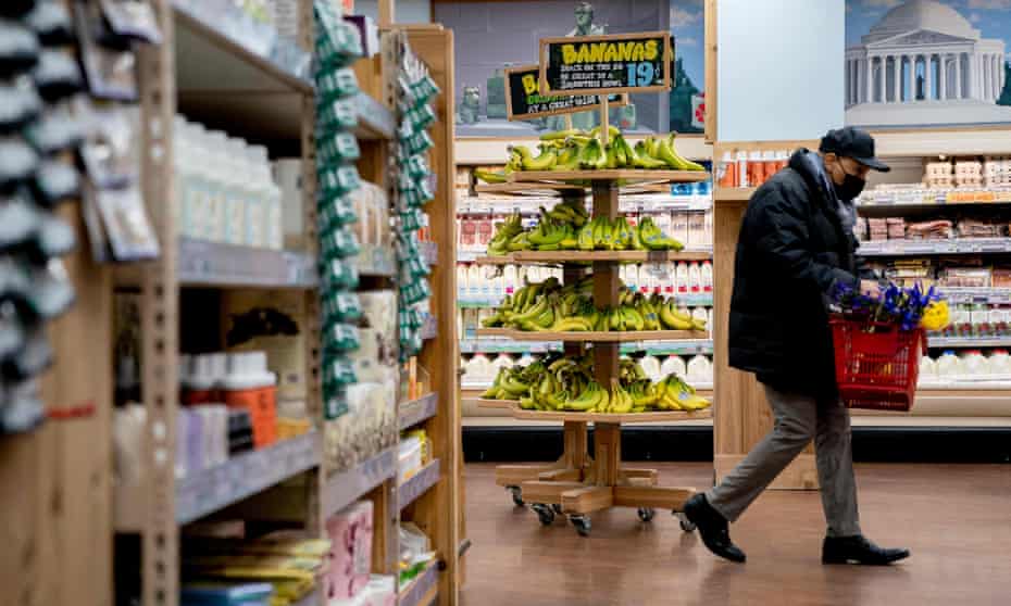 A shopper walks through a grocery store 