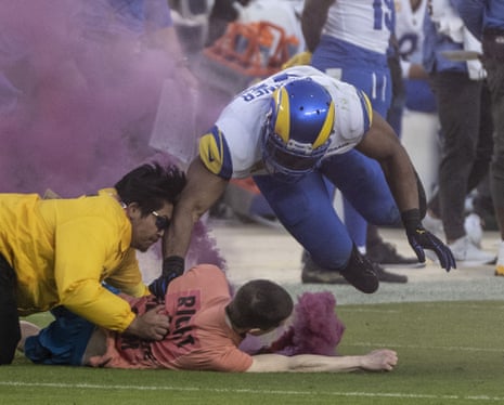 Los Angeles Rams linebacker Bobby Wagner (R) takes out a man with a smoke bomb who ran on the field in the second quarter of Monday Night Football featuring the San Francisco 49ers against the Los Angeles Rams at Levi's Stadium in Santa Clara, California on Monday, 3 October 2022.