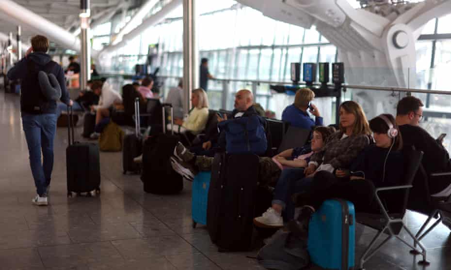 Passengers resting on benches at Heathrow