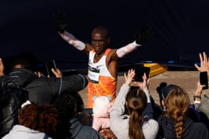 Eliud Kipchoge waves to spectators