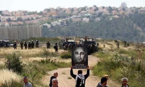 A placard of Nasser Abu Srour is held aloft during a demonstration marking Palestinian Prisoner Day in the West Bank town of Bilin, near Ramallah.