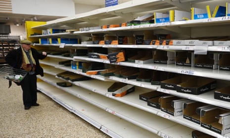 An elderly man scans the empty shelves of a north London supermarket