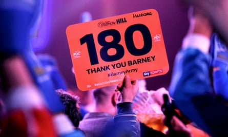 A fan holds a 180 sign with a thank you message to Raymond van Barneveld at Alexandra Palace in 2019.